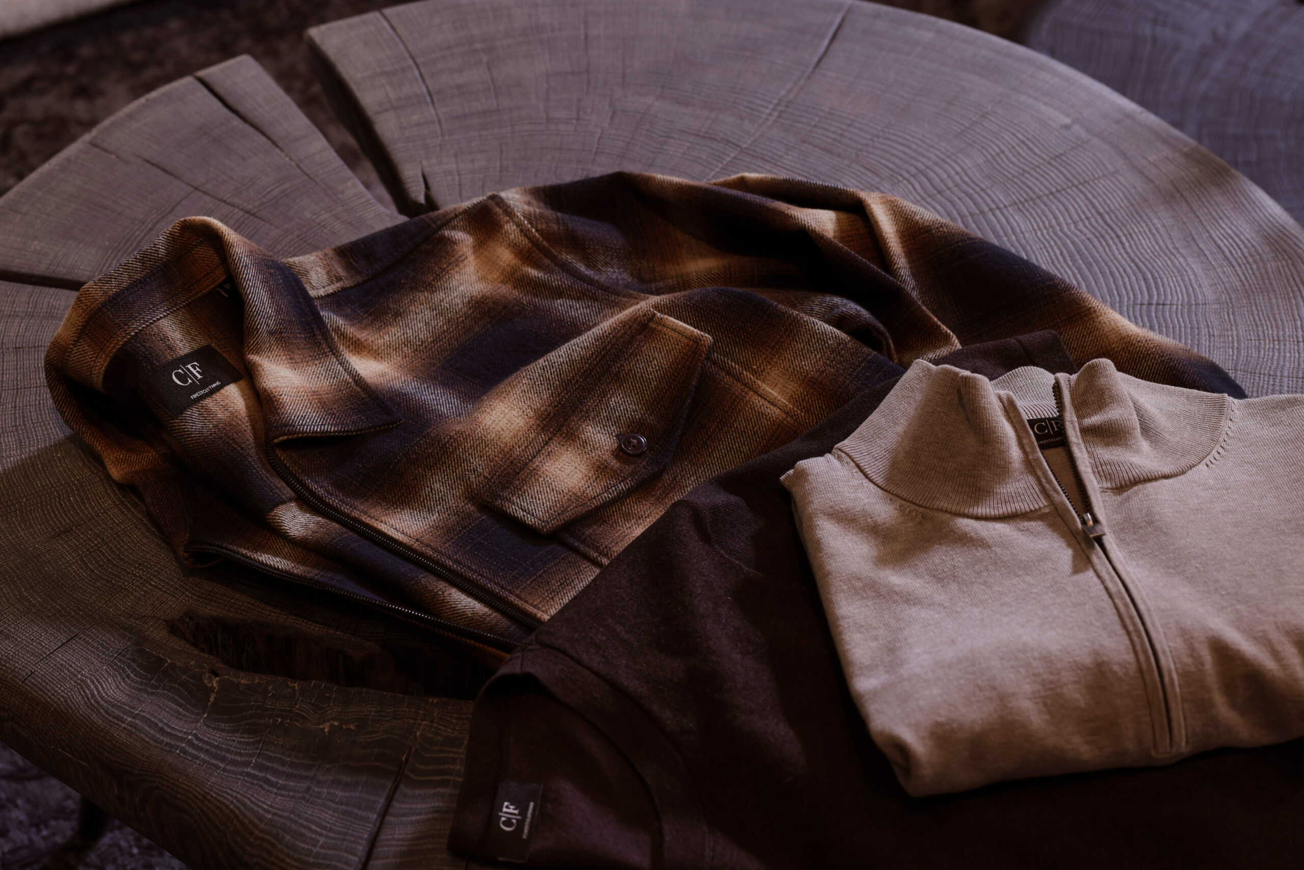 Stilvolle Herren-Kombination aus kariertem Overshirt, dunklem Oberteil und hellem Troyer-Pullover – modern, hochwertig und perfekt für smarte Casual-Looks von Commander Finest Clothing