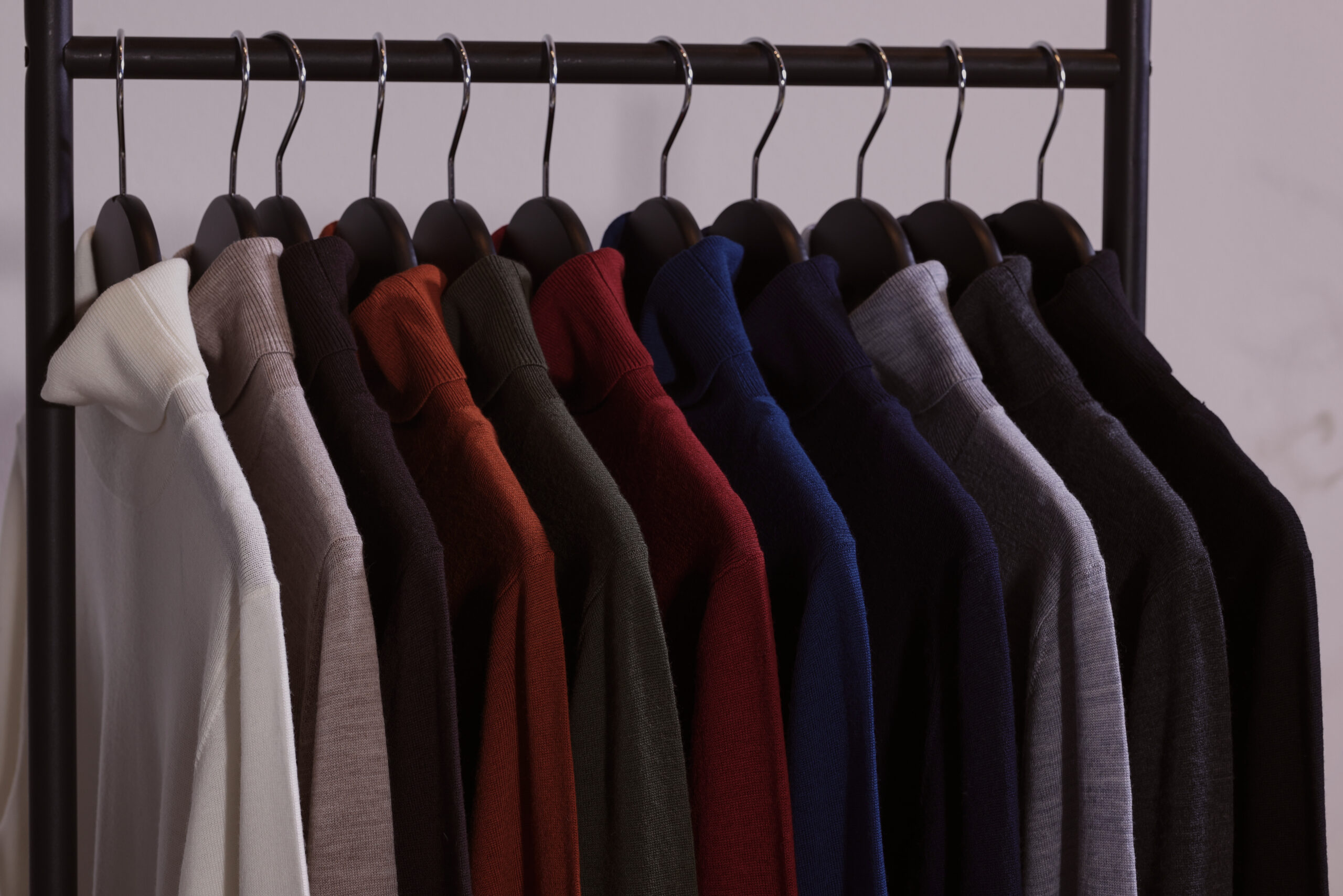 Herbstlich, winterliche Farbvielfalt: Hochwertige Merino-Rollkragenpullover in verschiedenen modernen und klassischen Farbtönen auf der Kleiderstange